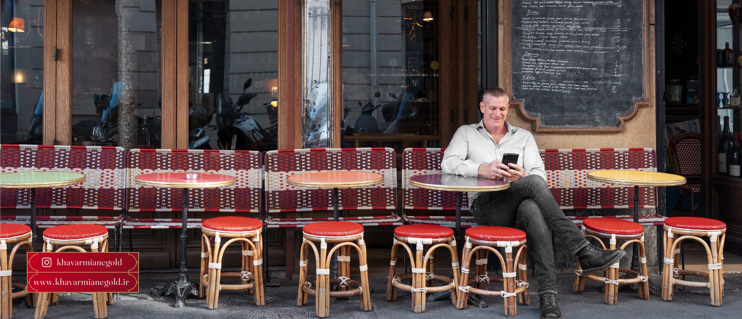 آقایی را نشان میدهد که در صندلی بیرون از رستورانی نزدیک بازار طلا و جواهر خاورمیانه نشسته و لذت میبرد.